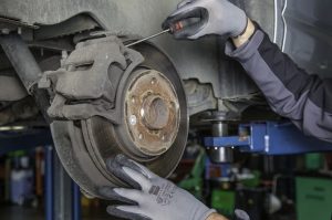 Close view of a mechanic working on one wheels brakes. | Hyundai service center in Little Rock, AR.