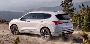 Profile view of a parked white 2021 Hyundai Santa FE parked in a forested area. | Hyundai service center in Little Rock, AR.