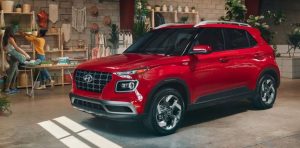 A red 2020 Hyundai Venue parked in a spacious garage with two people arranging things near the wall. | Hyundai service center in Little Rock, AR.