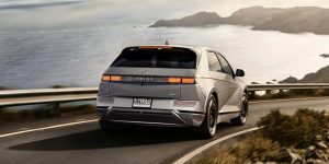 A 2022 Hyundai Ioniq-5 being driven on the highway with a body of water out in front. | Hyundai dealer in Little Rock, AR.