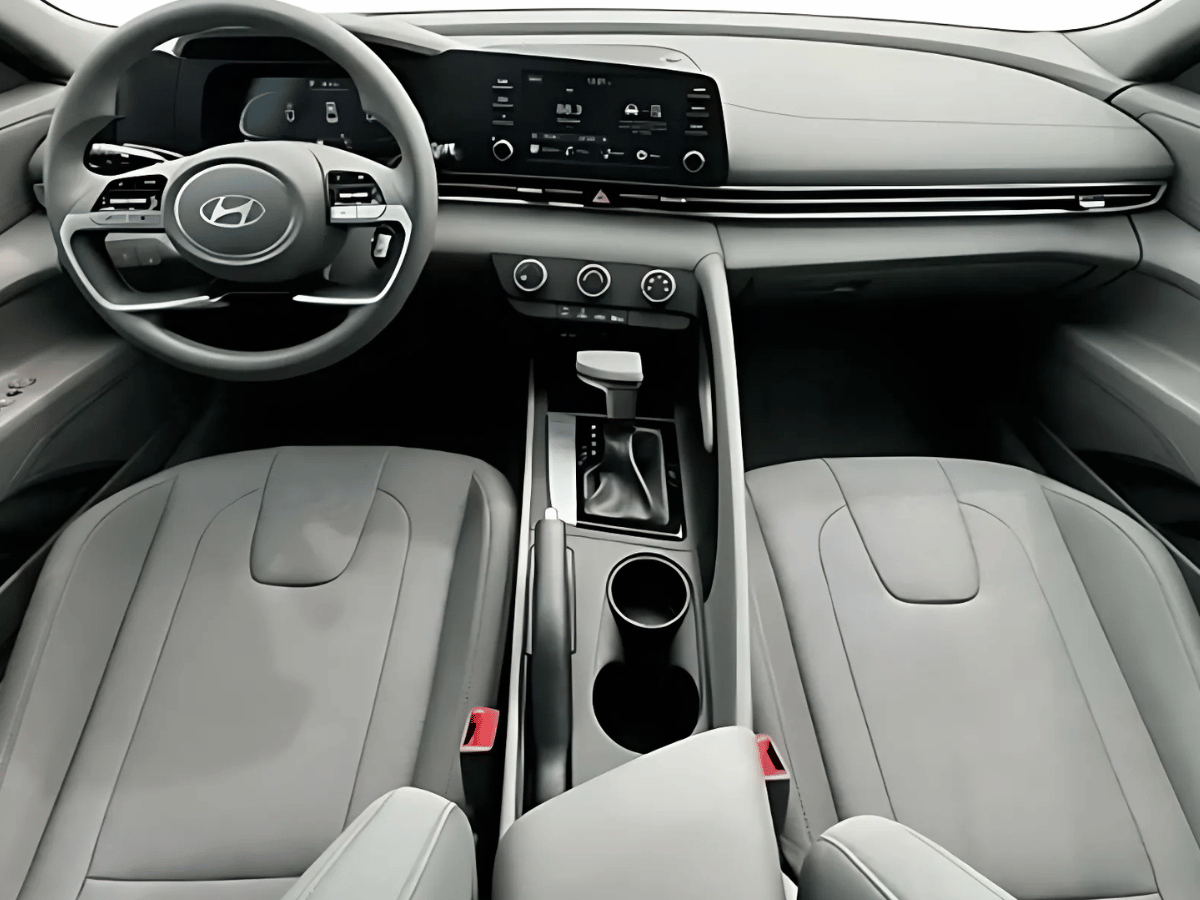 Interior view of the 2025 Hyundai Elantra featuring modern dashboard, infotainment screen, and gray leather seats