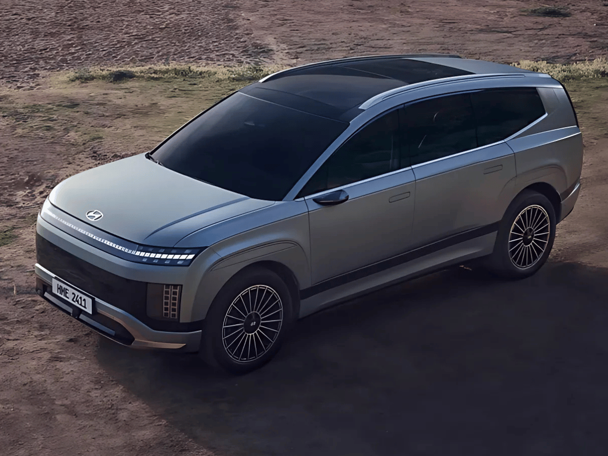 The all-new Hyundai Ioniq 9 electric SUV parked on a dirt overlook, showcasing its sleek futuristic design and panoramic roof.